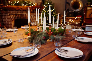 A nicely set table for the holiday season with candles.